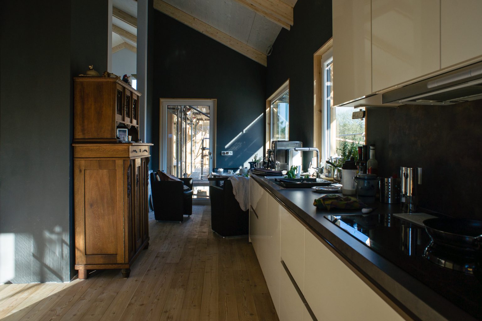 Innenperspektive Küche mit Holzdielenboden und dunkeln Wänden. Anstrich mit raumklimafreundlichen Lehmfarben