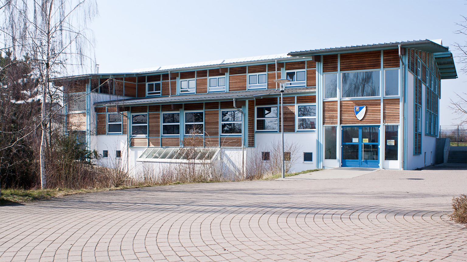 Südansicht Sportheim mit zentralem Gastrobereich und darüber liegenden Büros und Funktionsräumen