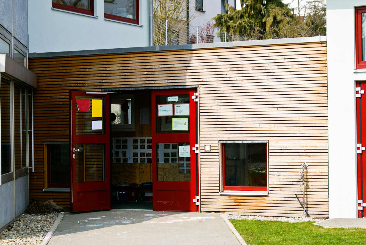 Großzügige rote Eingangstür als Blickfang in neuem Haupteingang der Kindertagesstätte, Elchingen bei Ulm