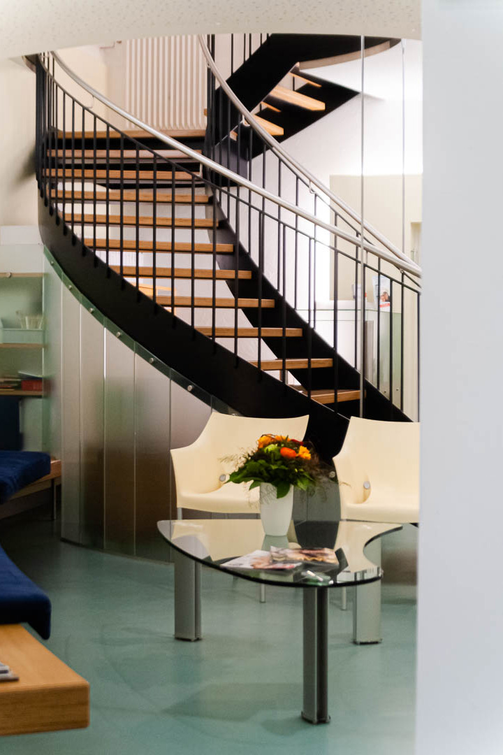 Kontrastreiches Farben- und Lichtspiel Wendeltreppe aus Stahl mit Holzstufen, stabil und gleichzeitig leicht in der Optik